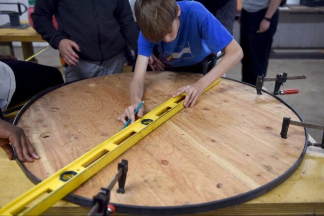 boy measuring round table