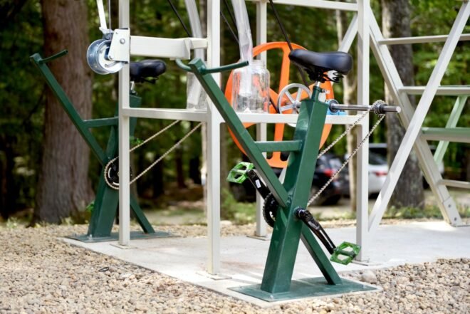 green stationary bike attached to a larger machine