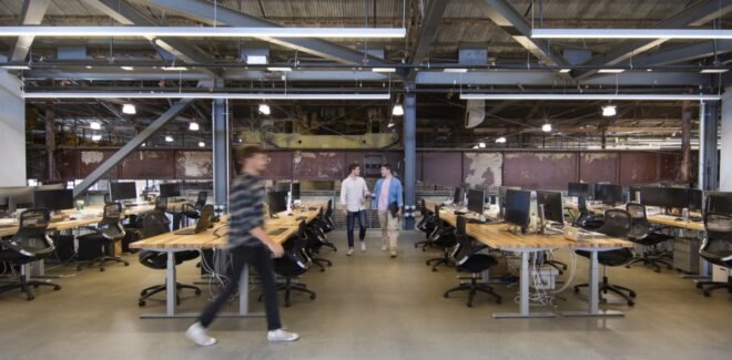 people walking beside rows of wooden desks