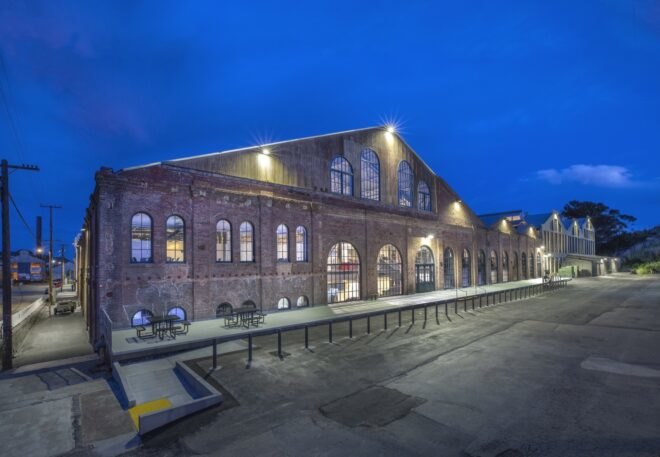 huge brick building with gabled roof lit up at night