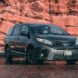 dark campervan in front of red mountain