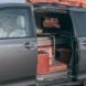 dark camper van with side door open, revealing living space inside