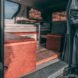 dark camper van with side door open, revealing living space inside