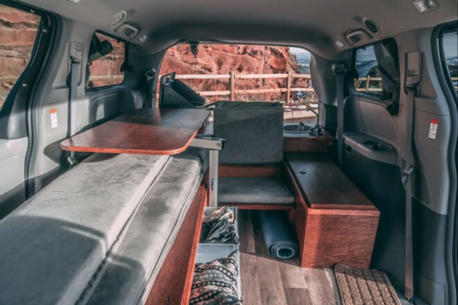 dark camper van with side door open, revealing living space inside