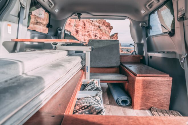 dark camper van with side door open, revealing living space inside