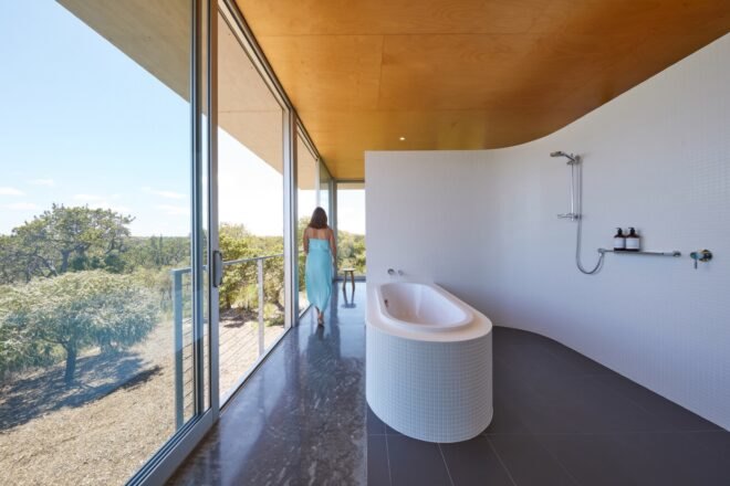 bathroom with freestanding tub and full-height sliding glass doors