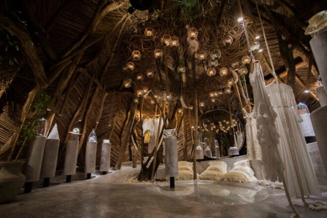 thatched room with hanging dresses