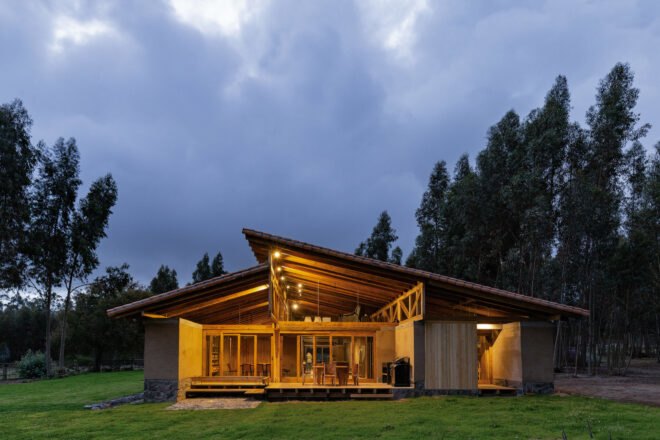 rammed earth home lit from within at night
