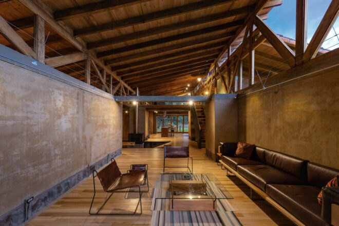room with rammed earth walls and brown leather sofa
