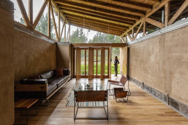 person standing in doorway of rammed earth home