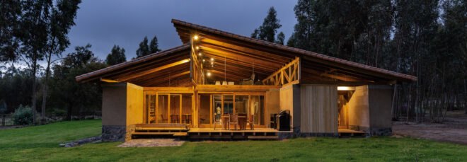 rammed earth home lit from within at night