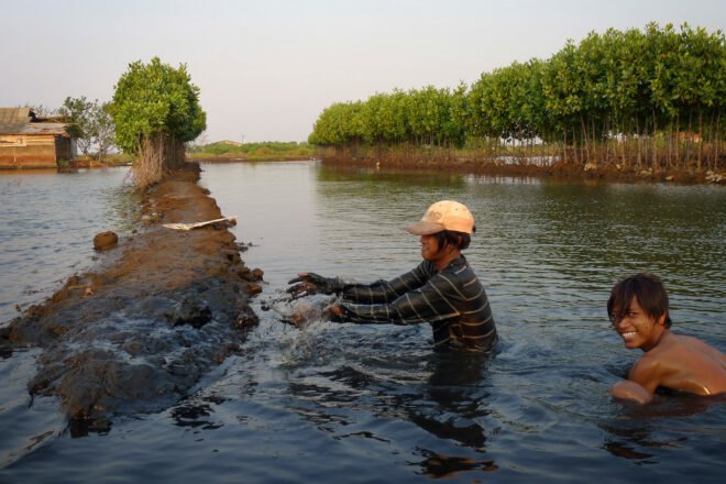 two people building a shrimp farm