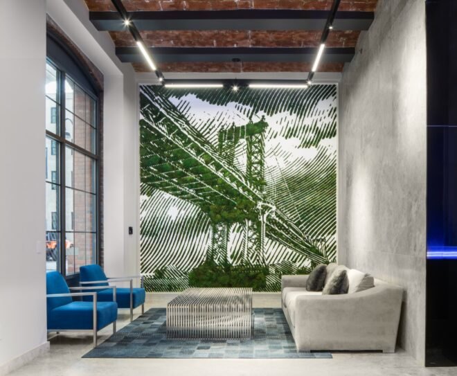 white room with white couch and blue chairs and motif of the Brooklyn bridge on the wall