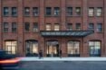 people walking by entrance to old brick building