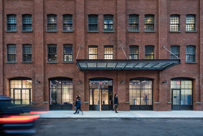 people walking by entrance to old brick building