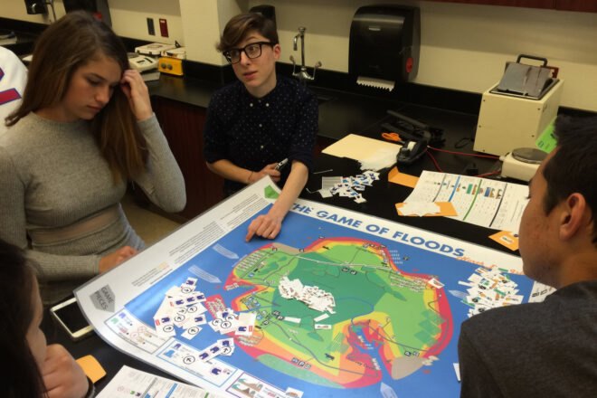 teenagers gathered around board game