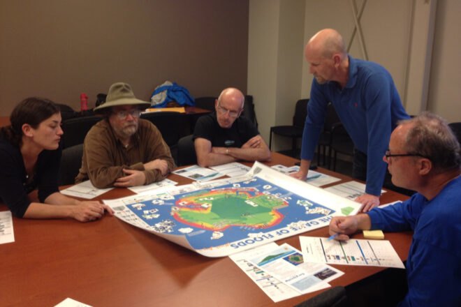 adults gathered around board game