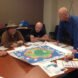 adults gathered around board game