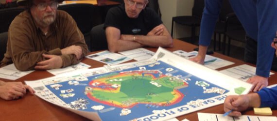 adults gathered around board game