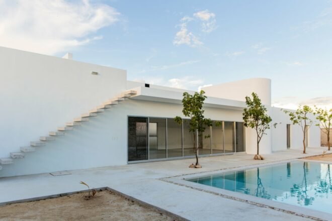 white home with floating stairs and a swimming pool