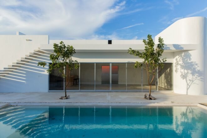 swimming pool in front of a white home