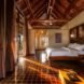 bedroom with stone tile floors and large wood bed