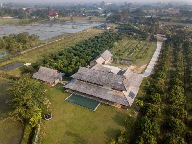 aerial view of home with multiple pitched roofs and gardens