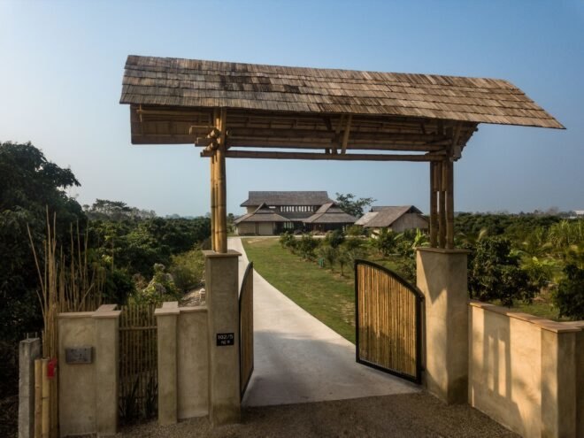 bamboo gate open and leading to a white home
