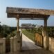 bamboo gate open and leading to a white home