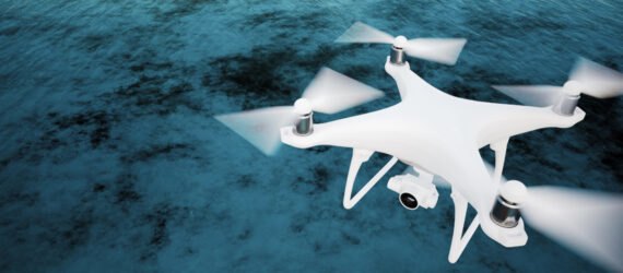 white drone flying over ocean