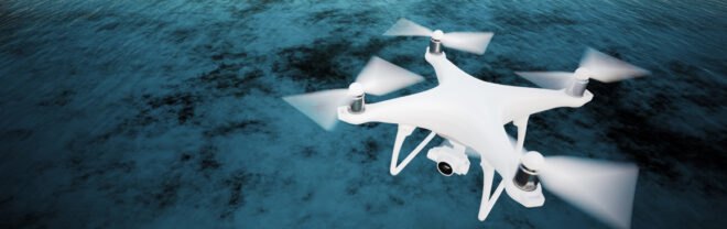 white drone flying over ocean