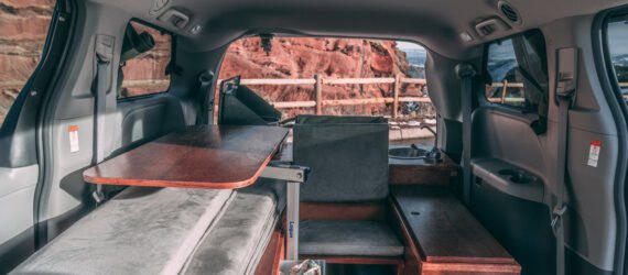 dark camper van with side door open, revealing living space inside
