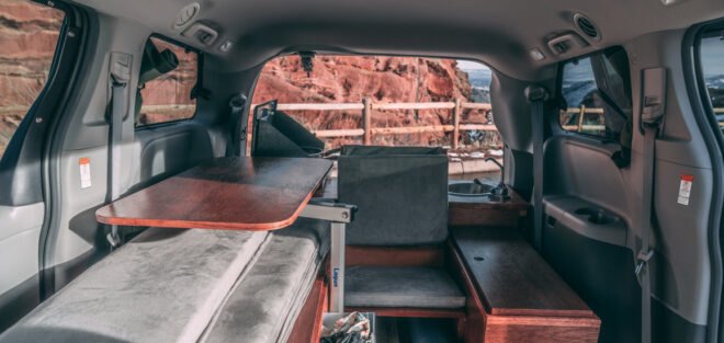 dark camper van with side door open, revealing living space inside