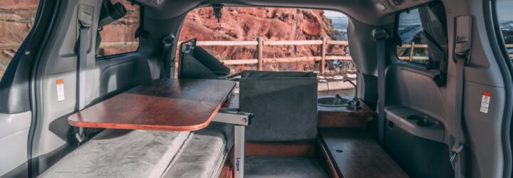 dark camper van with side door open, revealing living space inside