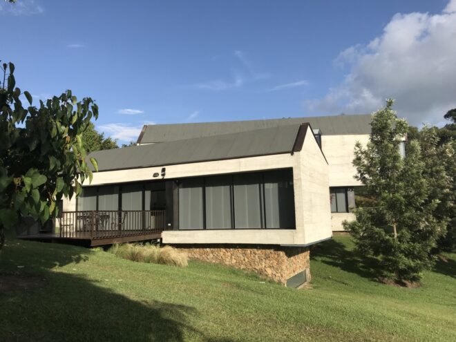 concrete building with gabled roof and large windows