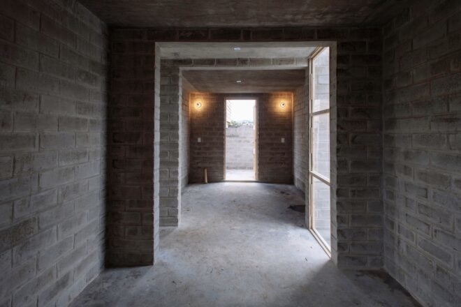 hallway with gray brick walls and large windows