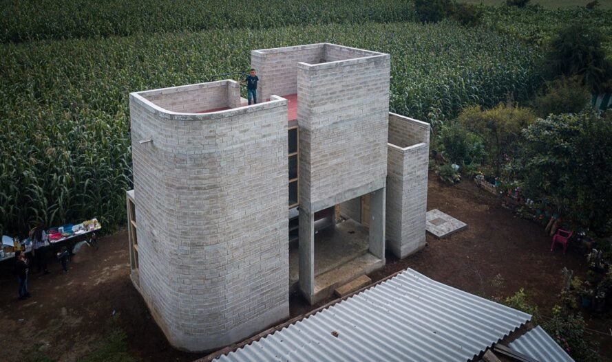 multi-story home built from gray earth blocks