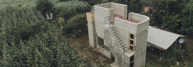 concrete and rammed earth home surrounded by plants