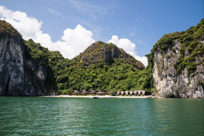 series of thatched roof huts on a remote beach