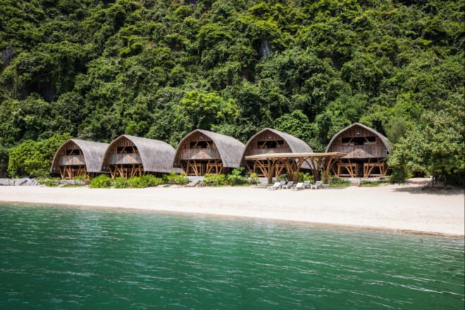 series of thatched roof huts on a remote beach