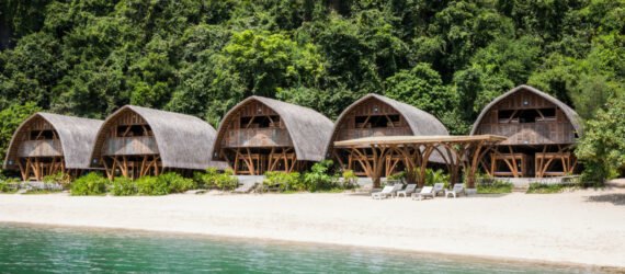 series of thatched roof huts on a remote beach