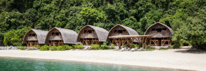 series of thatched roof huts on a remote beach