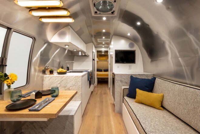 Aistream interior with sofas, small kitchen and a TV on the wall