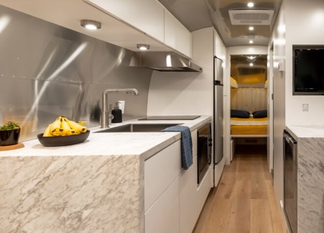 a white and marble kitchen inside an airstream