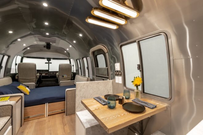a wooden dining nook with an adjacent kitchen