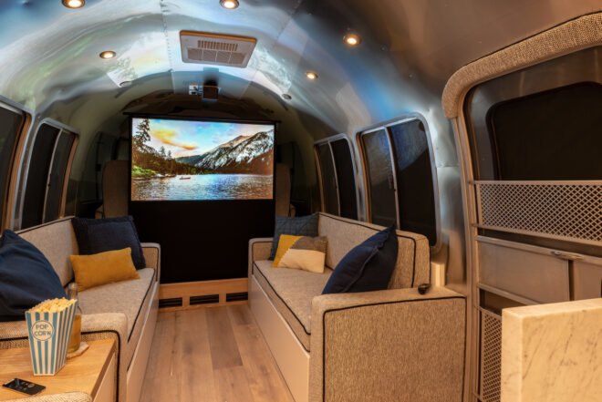 two sofas with a flat-screen TV on the wall