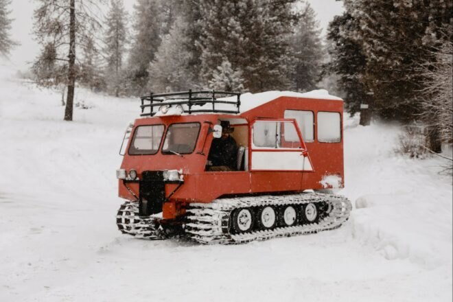 a red snowcat vehicle sitting in snow