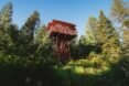 Red lookout tower surrounded by greenery