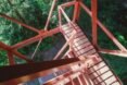 red stairs leading from green ground to a cabin