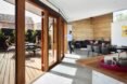 living room with dark couch and doors opening to a wood patio